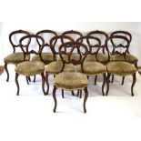 A set of six Victorian walnut balloon back dining chairs with moulded frames and upholstered seats