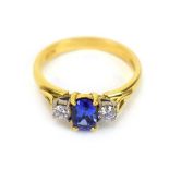 An 18ct yellow gold ring set oval tanzanite and two brilliant cut diamonds in an inline setting,