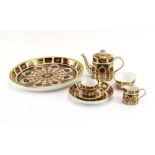 A miniature Royal Crown Derby bachelors' service comprising oval tray, teapot, trio,