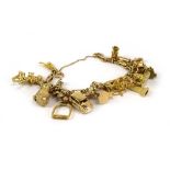A 9ct yellow gold bracelet suspending eighteen yellow gold and yellow metal charms including the