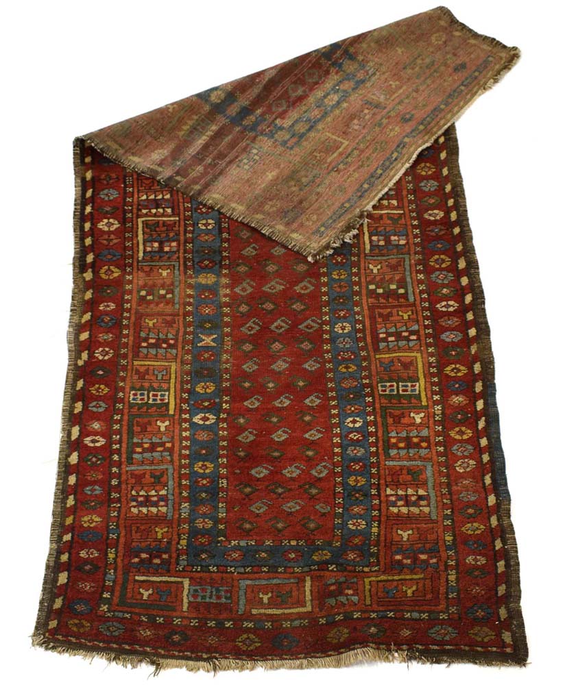 An early-to-mid 20th century runner, the red ground with blue and geometric bands and motifs,