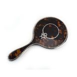 An early 20th century silver and tortoiseshell hand mirror in the Neo-Classical manner,