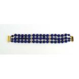 A 9ct yellow gold mounted three strand lapis lazuli bead bracelet, l. 18.