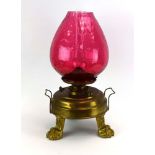 A Victorian oil lamp, the cranberry glass shade of honeycomb-form,