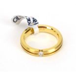 An 18ct matt yellow gold band ring set small brilliant cut diamond within a tension setting, band w.