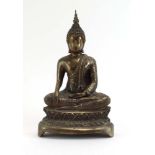A Far Eastern cast metal figure modelled as the Buddha in meditation on a lotus base, h. 21.