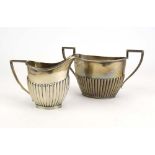 An Edwardian silver two handled sugar bowl with gadrooned decoration and a matching milk jug,