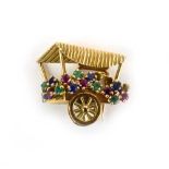 A French 18ct yellow gold clip in the form of a flower cart, set small emeralds,