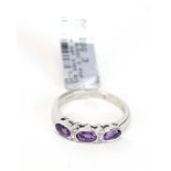 An 18ct white gold ring set three oval amethyst interspersed with four small diamonds,