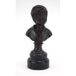 A bronze bust modelled as a child, on a marble plinth, h.