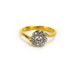An 18ct yellow gold crossover ring set nine brilliant cut diamonds in a flowerhead setting,