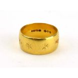 A 22ct yellow gold wedding band with engraved star decoration, London 1971, band w.