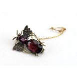 A metalware brooch in the form of a winged insect set red glass and small pearls l. 2.