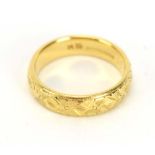 An 18ct yellow gold engraved wedding band, Birmingham 1985, band w. 4 mm, ring size N 1/2, 6.