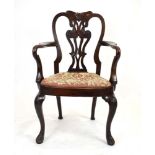 A 19th century mahogany elbow chair, the shaped and pierced splat over a needlework seat,