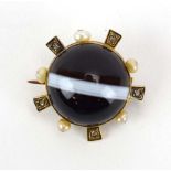 A Victorian yellow metal mourning brooch set circular cabochon banded agate within a border of five