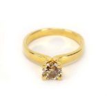 A 14ct yellow gold ring set brilliant cut diamond in a four claw setting,