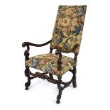 A 17th century French walnut and upholstered armchair with scrolled arms and legs and a cross