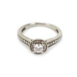 A platinum 'halo' ring set centrally with a brilliant cut diamond within a border of smaller