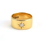 An 18ct yellow gold band ring set old cushion cut diamond in a recessed star setting,