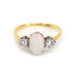 An 18ct yellow gold ring set oval opal and two brilliant cut diamonds, diamonds approximately 0.