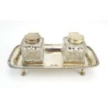 An Edwardian silver two bottle ink stand of rectangular form on four paw feet, Walker & Hall,