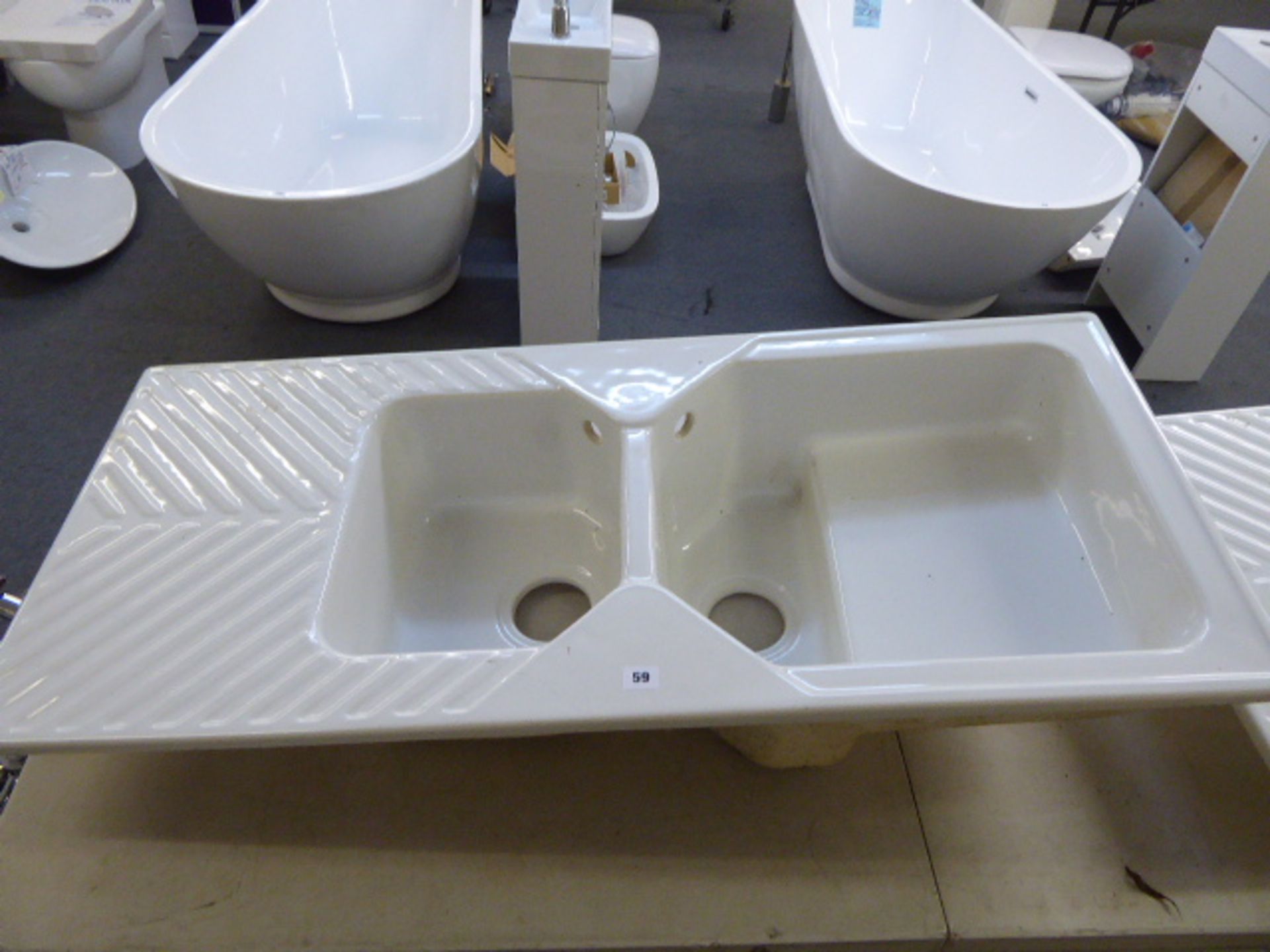 A white ceramic one and a half bowl inset sink unit