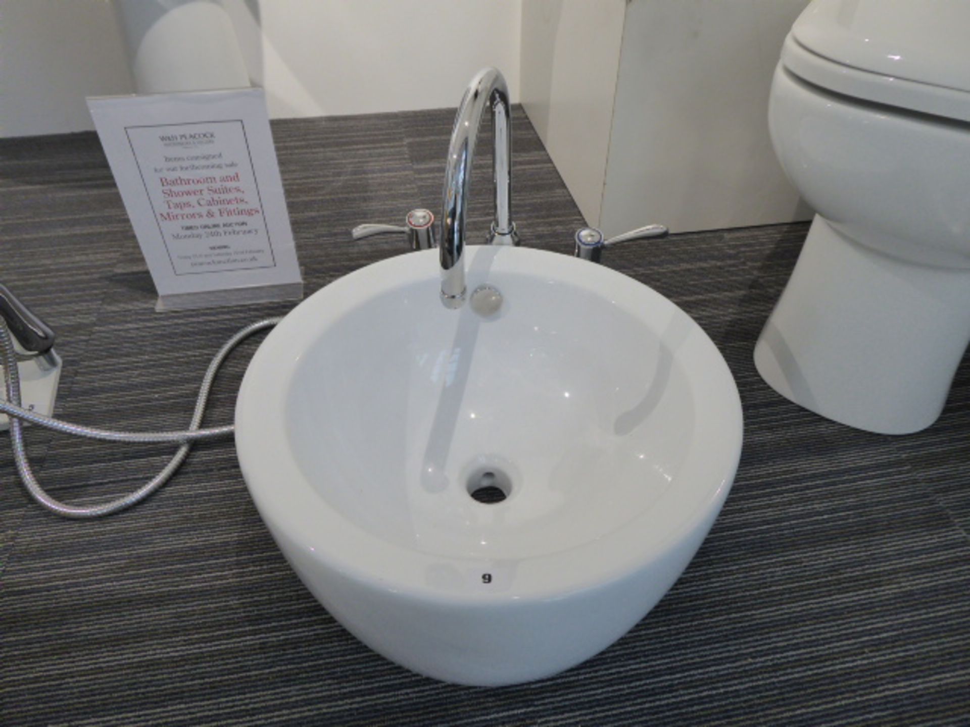 Circular white ceramic hand basin with mixer tap