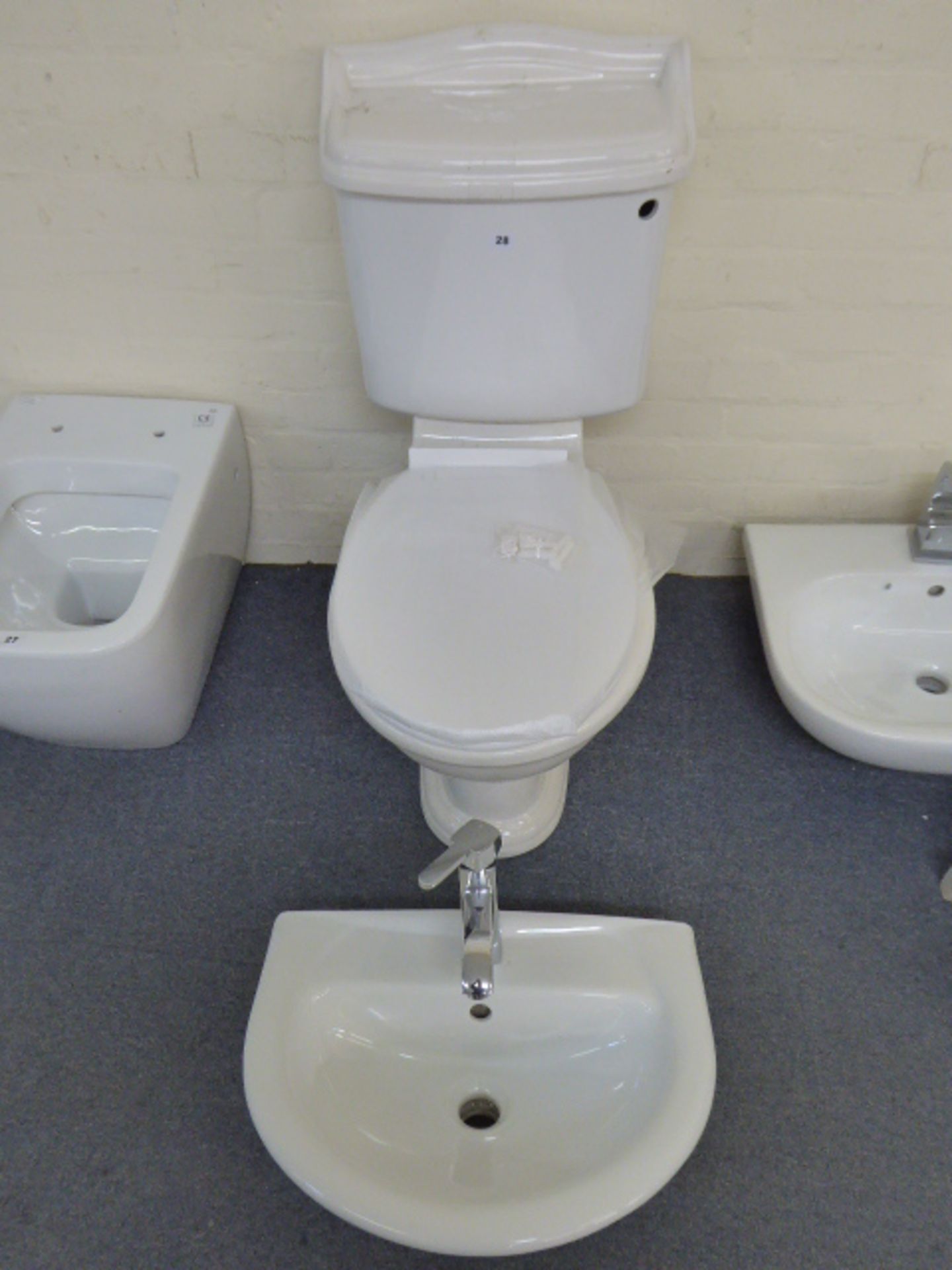 A cloakroom suite in traditional style comprising toilet cistern, soft close seat, wash hand basin