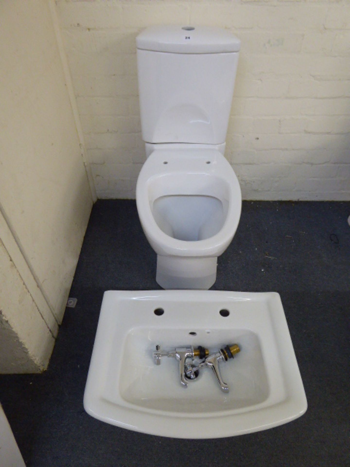 A cloakroom suite comprising toilet, close coupled cistern, wash basin, and taps