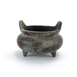A small Chinese green patinated bronze censer of traditional form on three peg feet,