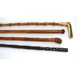 A group of four walking sticks including one with a horn handle and gilt mount,
