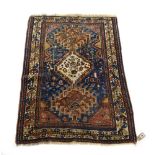 A Kazak rug, the cobalt blue field with three linked panels within an ivory border,