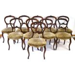 A set of six Victorian walnut balloon back dining chairs with moulded frames and upholstered seats