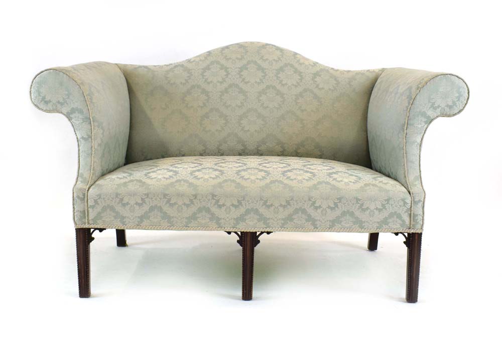 A Georgian and later wing backed two seater settee upholstered in a pale green damask-type fabric