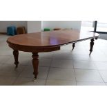 A Victorian mahogany extending dining table having three fitted leaves on reeded baluster legs,