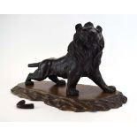 A Japanese brown patinated cast metal figure modelled as an outstretched lion, h. 26.