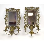 A pair of late 19th/early 20th century wall mirrors, the mirrored plates with relief borders,