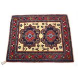 A Hamadan rug, the cream field with a pair of flowerhead medallions within a claret border,