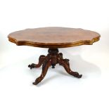 A Victorian figured walnut loo table, the scalloped surface above a carved quadrapite base, w.