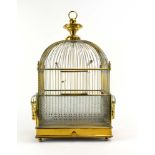 A 19th century brass birdcage with a domed top, etched glass sides, and spiral columns,