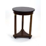An Empire-style side table, the circular black marble surface above a metal mounted tripod base, h.