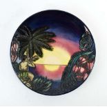 A limited edition Moorcroft cabinet plate for the year 2000 decorated with a tropical sunset on a