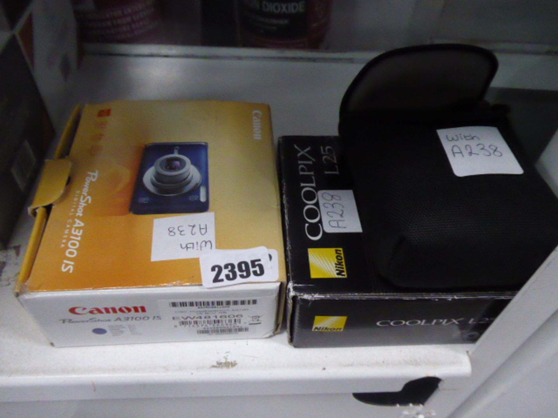 2502. Canon Powershot digital camera together with Nikkon CoolPix and one other camera loose in bag
