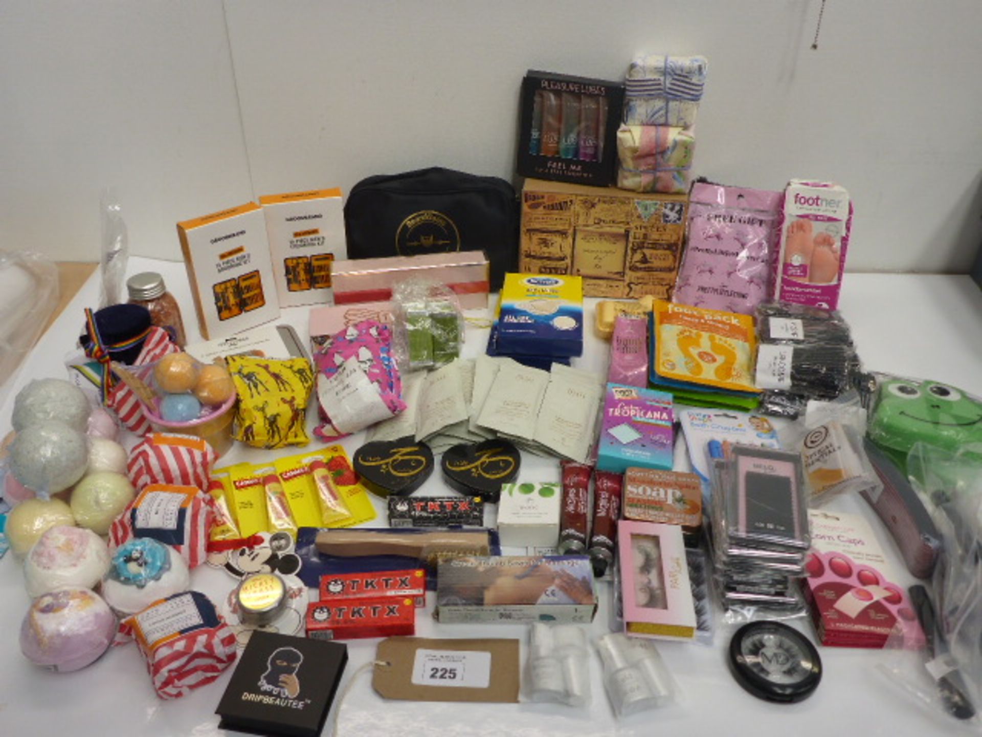 Large bag of beauty products including false eyelashes, soaps, bath bombs, lip balm, men's