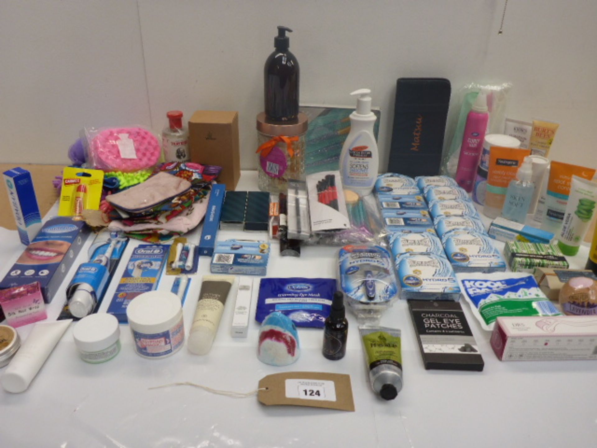 Bag containing razors, toothbrushes, makeup bags, cotton buds, soap, bath bombs, creams, lotions and