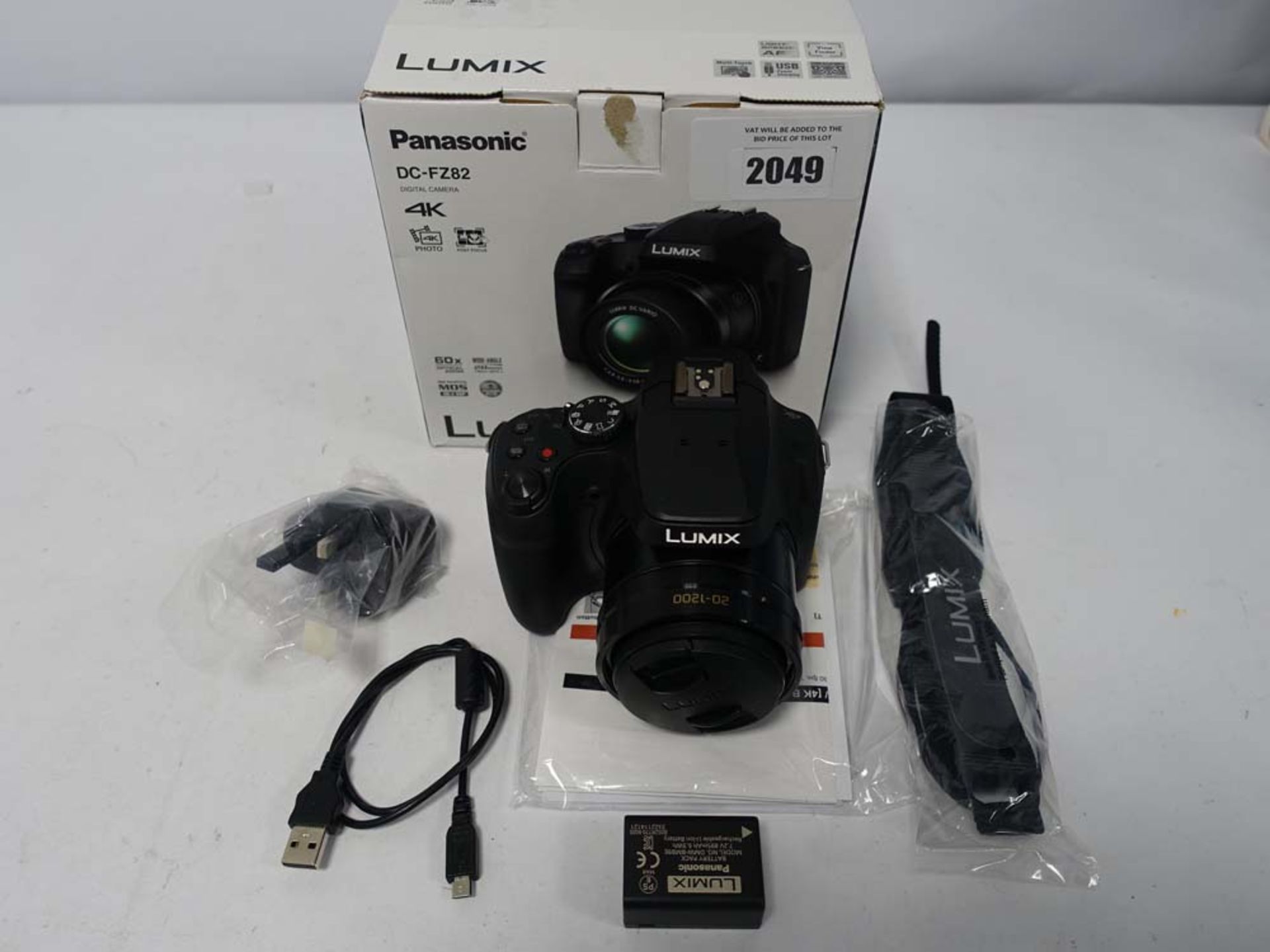 Panasonic Lumix DC-FZ82 4K bridge camera with battery charge cable and box.