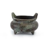 A small Chinese green patinated bronze censer of traditional form on three peg feet,