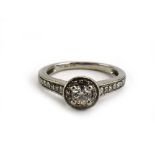 A platinum 'halo' ring set centrally with a brilliant cut diamond within a border of smaller