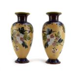 A pair of Doulton Lambeth stoneware vases of ovoid form typically relief decorated with flowering